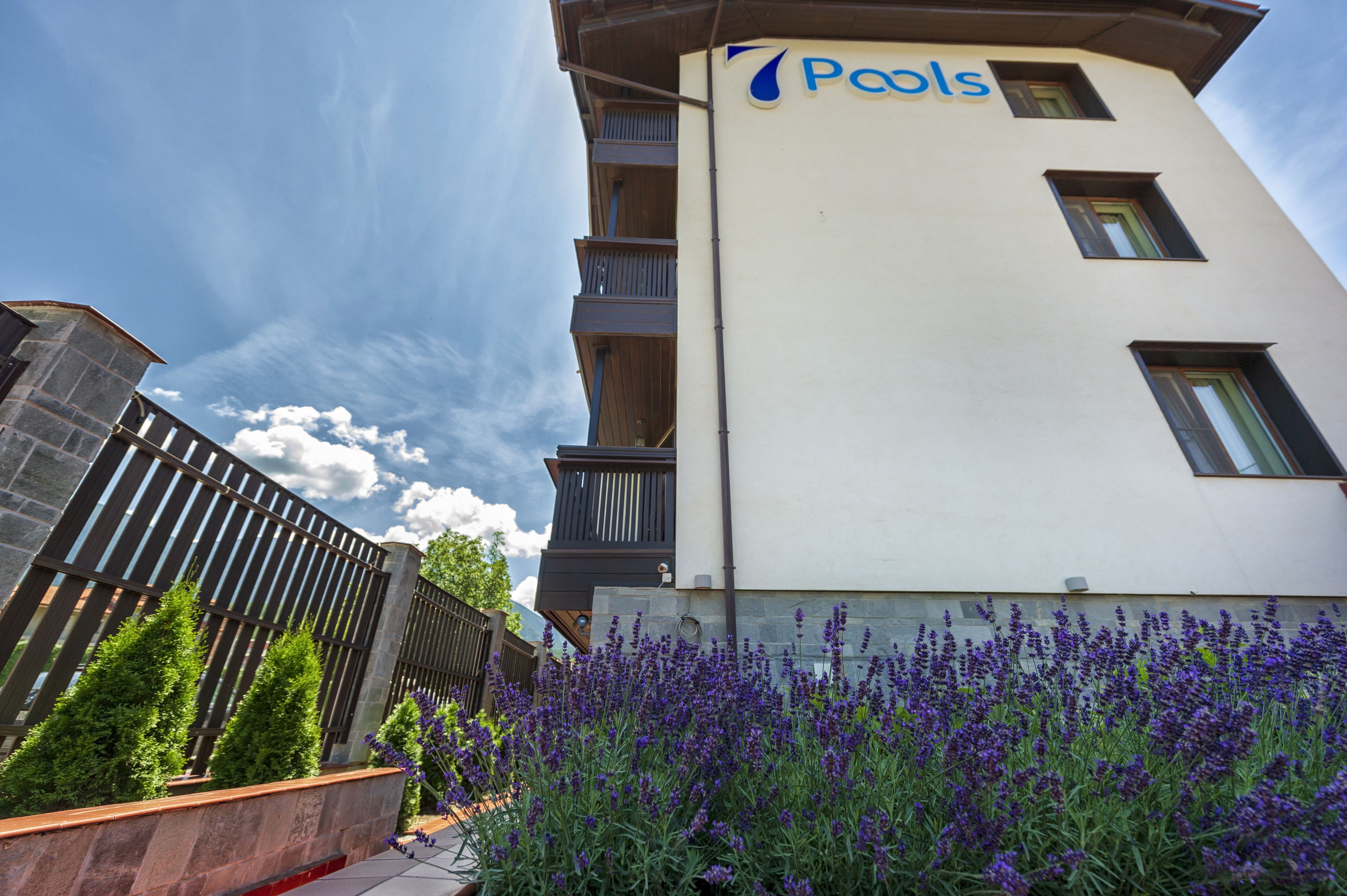 A hotel with a sign reading "Pools" on the exterior.