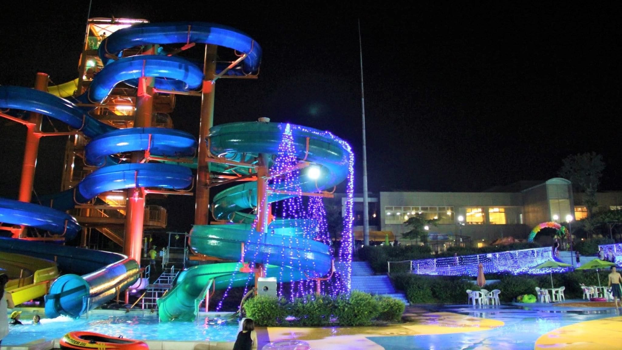 A water park with multiple slides and a building in the background.