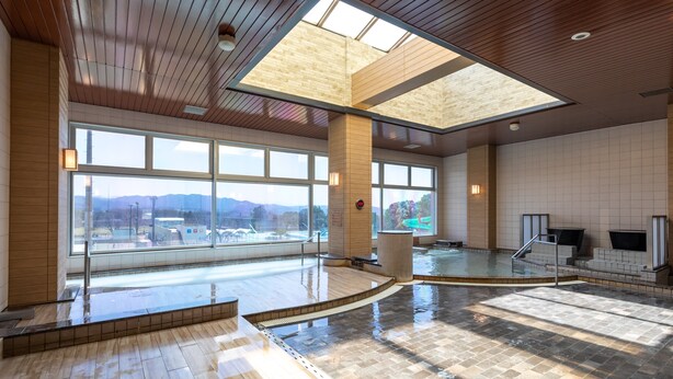 A spacious indoor pool area with large windows, a wooden ceiling, and a view of mountains. - Aso Kumamoto Airport Hotel Eminence (Mashiki)
