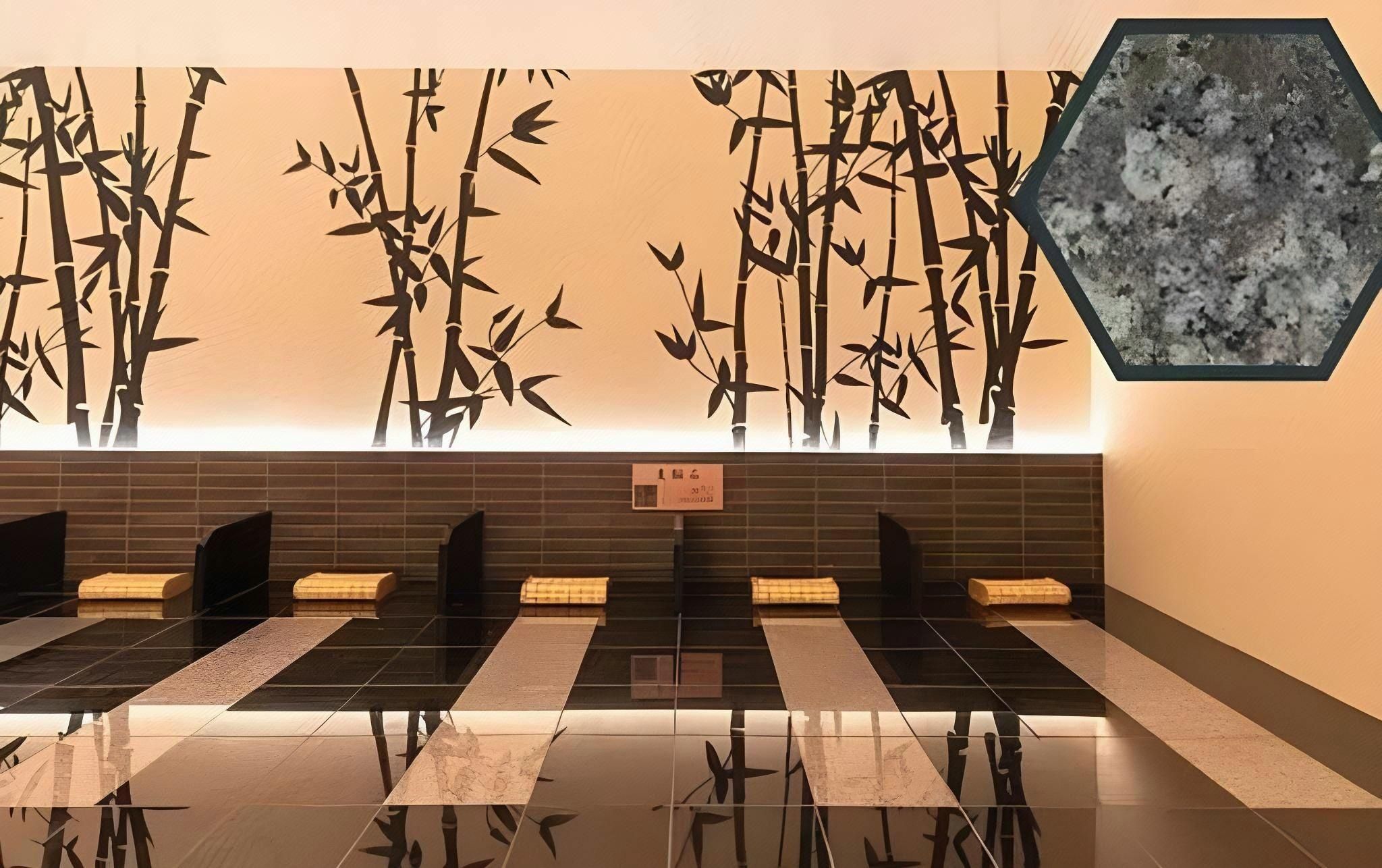 A modern bathroom with a bamboo wall design, a tiled floor, and a hexagonal mirror.