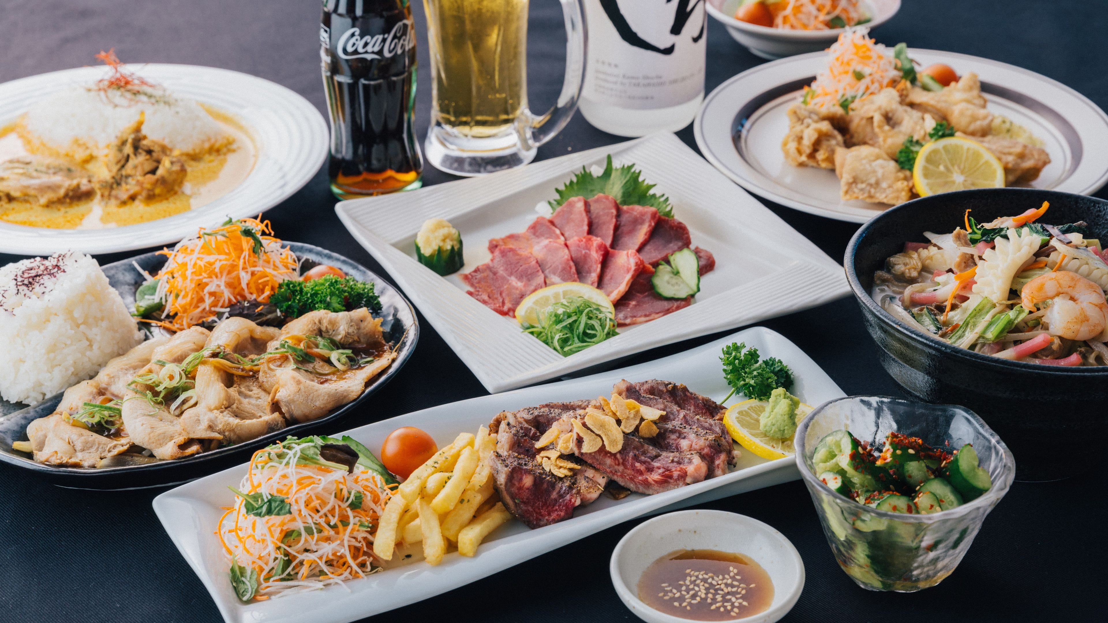 Variedad de platos sobre una mesa, incluyendo arroz, carne y verduras.