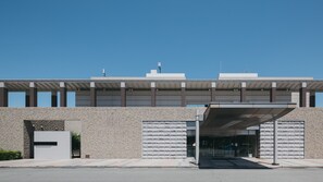 Un bâtiment moderne doté d’un toit plat, de grandes fenêtres et d’une entrée abritée.