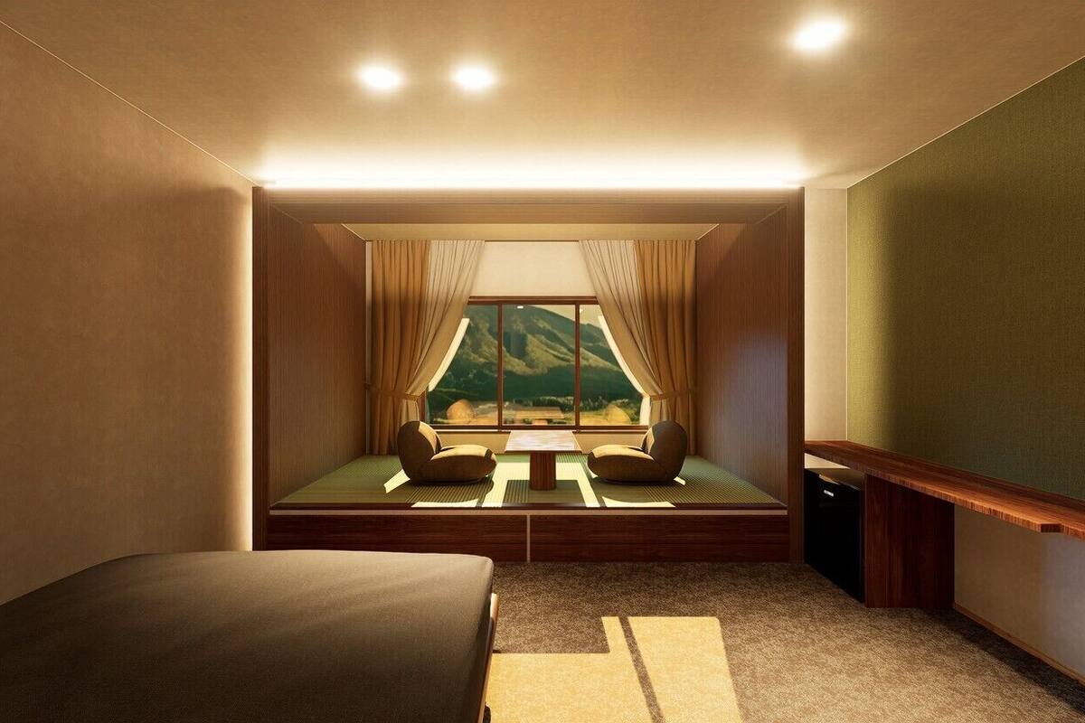 A room with a bed, a small table, a window with curtains, and a view of a mountain landscape.