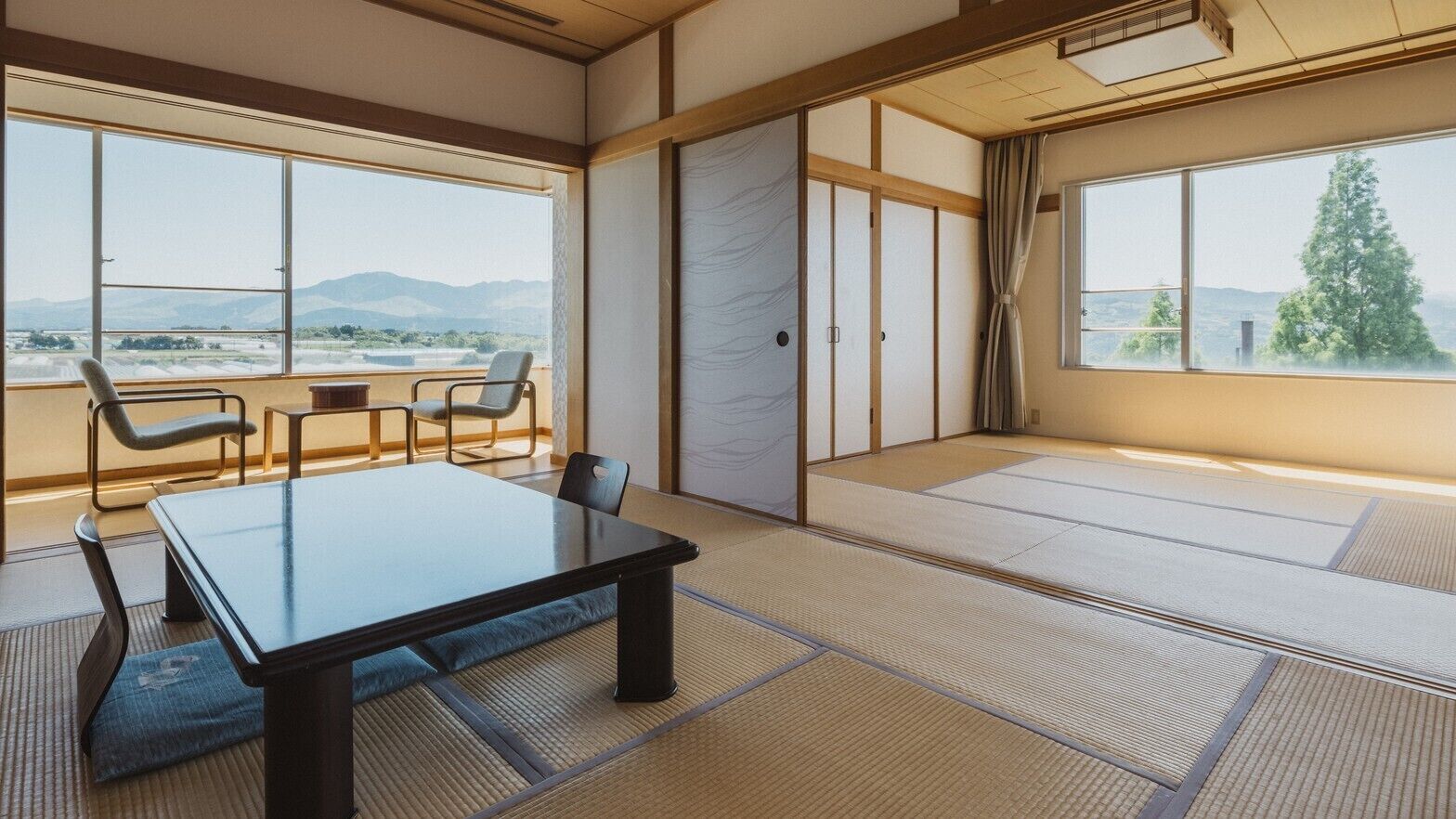 Ein traditioneller japanischer Raum mit Tatami-Böden, einem niedrigen Tisch und Schiebetüren.