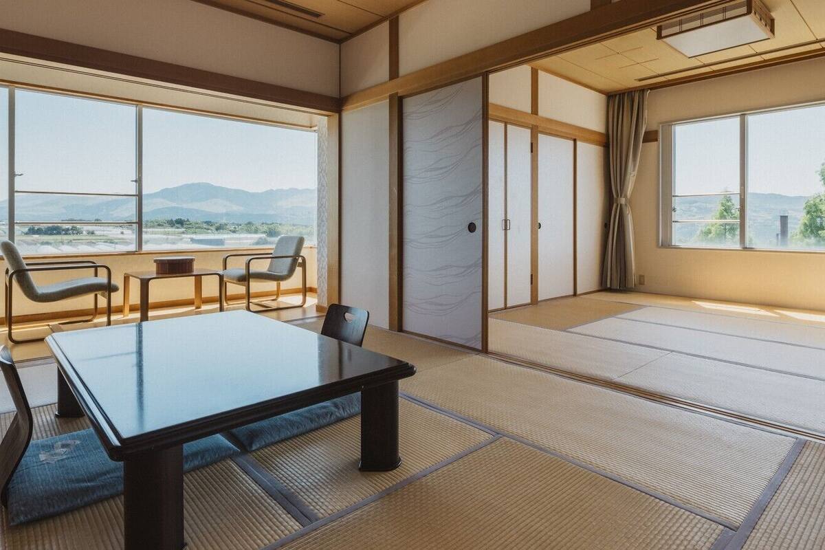 A traditional Japanese room with tatami flooring, a low table, and sliding doors.