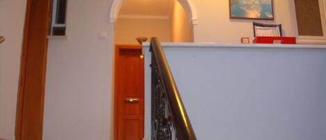 Un escalier avec une rampe en bois menant à un palier.