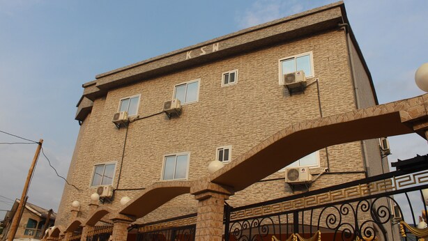 Un edificio de varios pisos con fachada de ladrillo, varias ventanas y unidades de aire acondicionado.