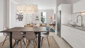 Una cocina moderna con armarios blancos, un refrigerador de acero inoxidable y un horno empotrado.
