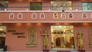 Fachada del Hotel Bagan Comfort con una entrada destacada, un balcón con barandilla y estatuas decorativas.