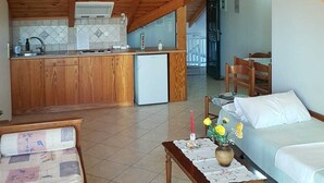A cozy room with a wooden ceiling, a kitchenette, a bed, and a dining area. - Villasabella (Zakynthos)