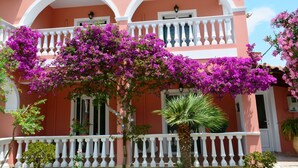 A pink building with white balconies and purple bougainvillea. - Villasabella (Zakynthos)