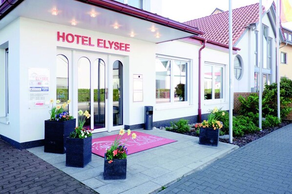 A hotel named HOTEL ELYSEE with a modern facade, large windows, and a red-tiled roof. - Hotel Elysee (Seligenstadt)
