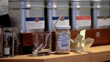 A shelf with various containers, including a jar labeled 'Kathrin's Liebster Karamel-Toffee Zucker' and a glass with a spoon.