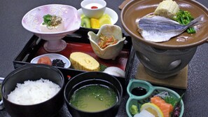 Un assortiment de plats, notamment du poisson, du riz et de la soupe, servis sur un plateau.