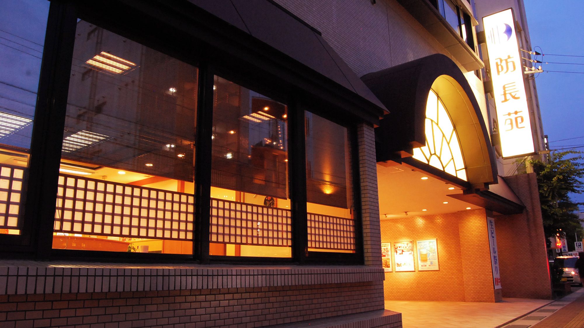 A building with large windows and a sign with Japanese characters.