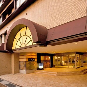 Ein Hotel mit modernem Design, das einen gewölbten Bogen und eine Glasfassade zeigt.