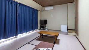 A room with tatami flooring, a wooden table, a television, and a white air conditioning unit. - Tabist Business Hotel Japan Takamatsu Kagawa (Takamatsu)