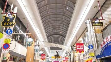 An indoor shopping area with a curved ceiling, various signs, and a central archway.