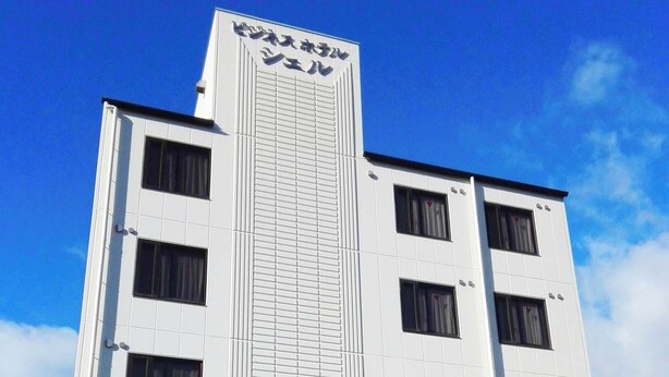 Ein modernes Gebäude mit markantem, vertikalem Teil und vielen Fenstern.