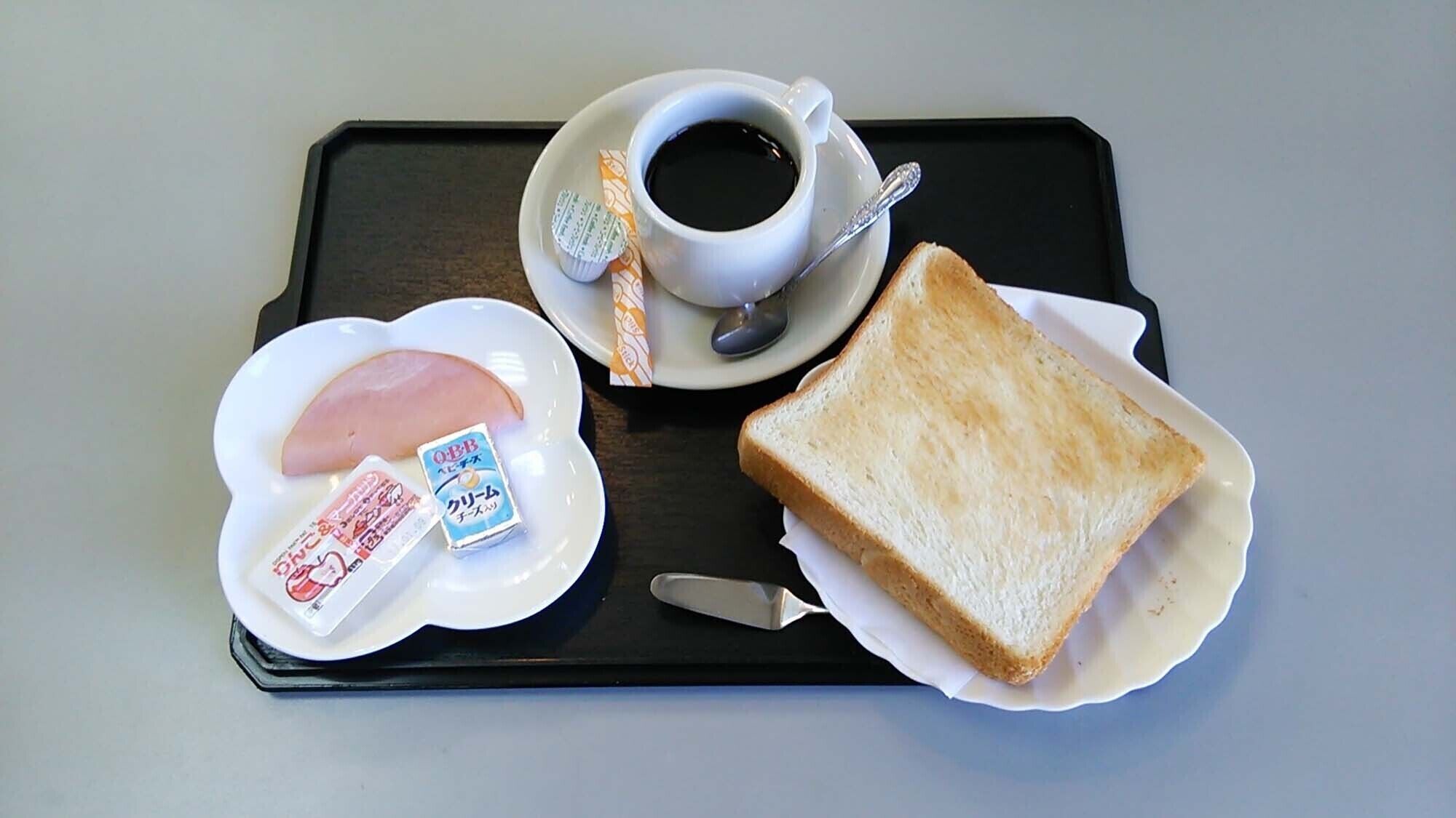 A tray with a cup of coffee, a slice of toast, a ham sandwich, and two packets of instant noodles.