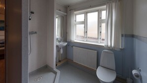 Ein kleines Badezimmer mit Dusche, Toilette und Waschbecken.