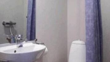 Ein Badezimmer mit einem weißen Waschbecken, einem Spiegel und einer Toilette.