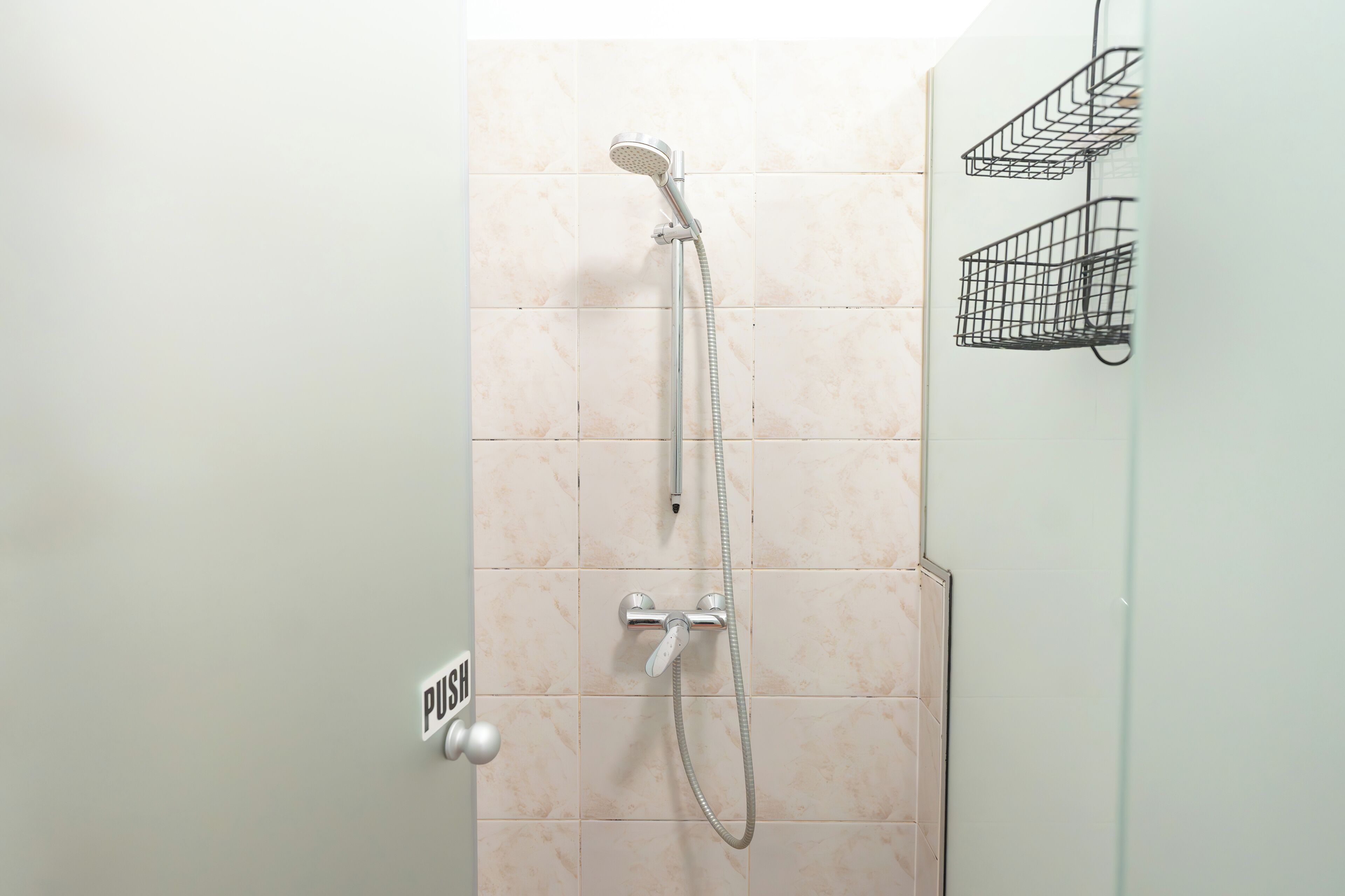 Une douche équipée d’un pommeau de douche et d’un flexible à main.