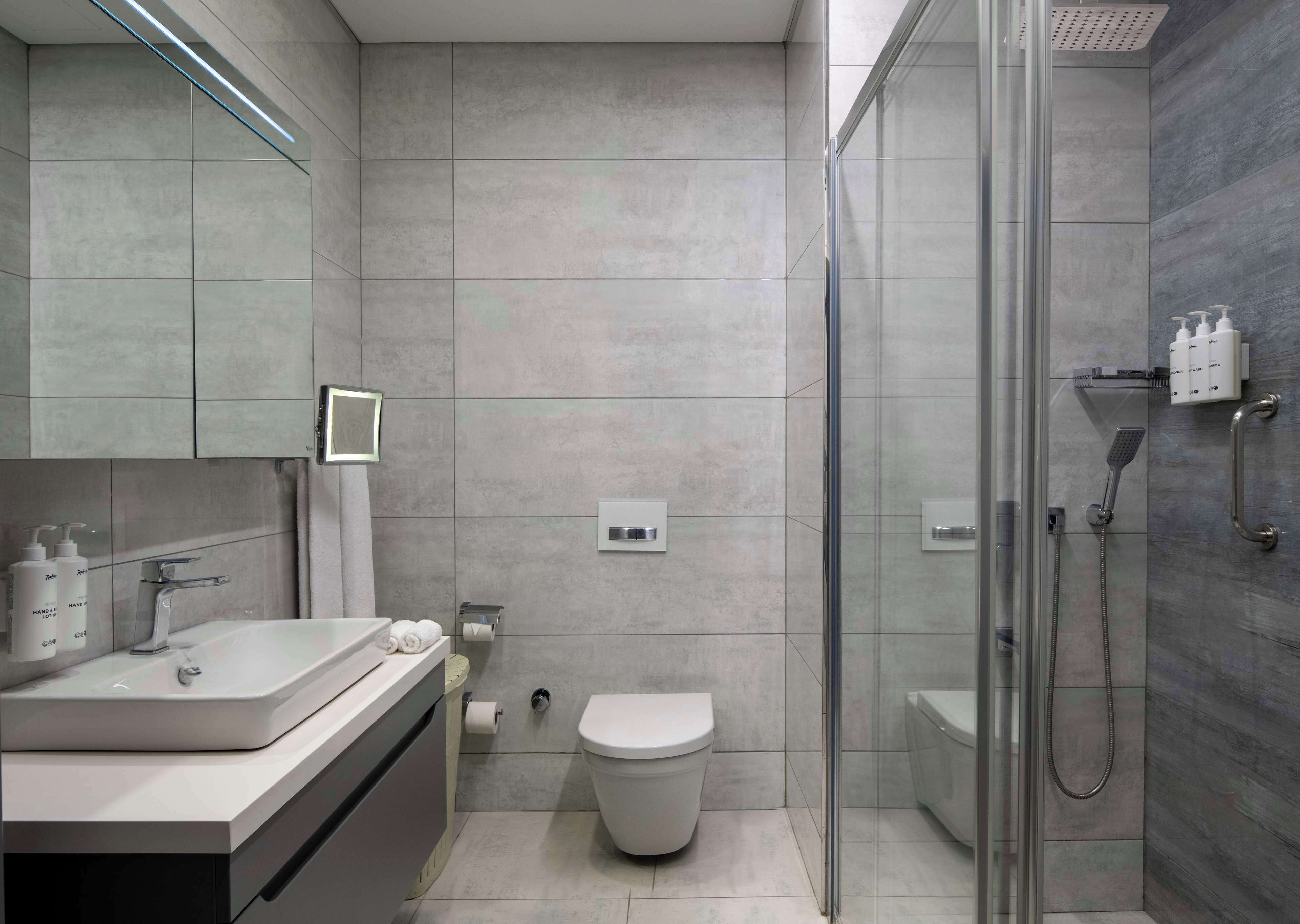 A modern bathroom with a shower, toilet, and vanity.