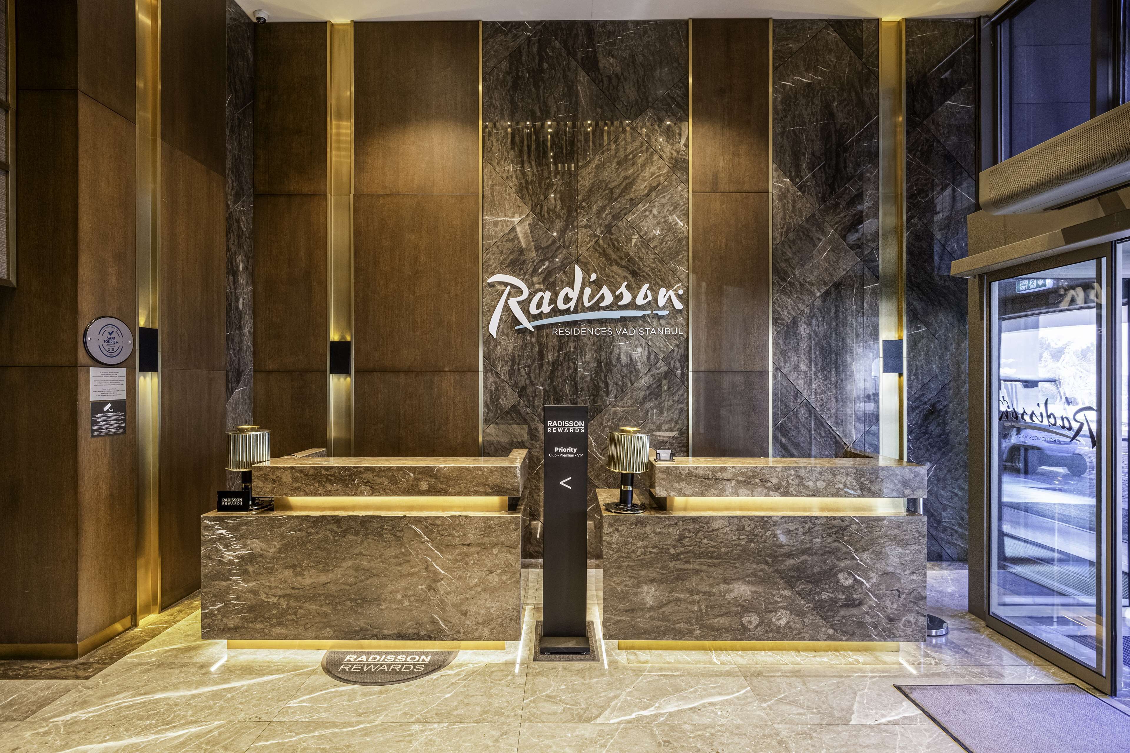 A reception area with a marble wall and a sign for Radisson Residences in Istanbul.