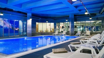 Una piscina techada, sillones reclinables de piscina