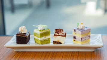 Cuatro tipos diferentes de pasteles en capas sobre un plato rectangular blanco.