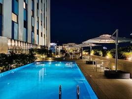 Una piscina al aire libre, sillones reclinables de piscina