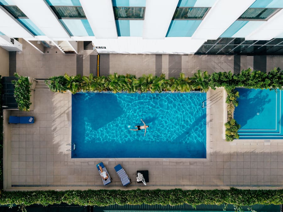 Una piscina al aire libre, sillones reclinables de piscina