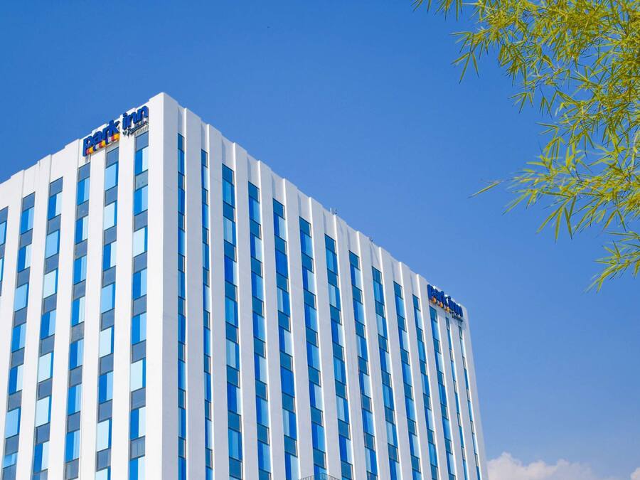 A tall hotel building with a modern design, featuring a series of windows and a prominent sign at the top.