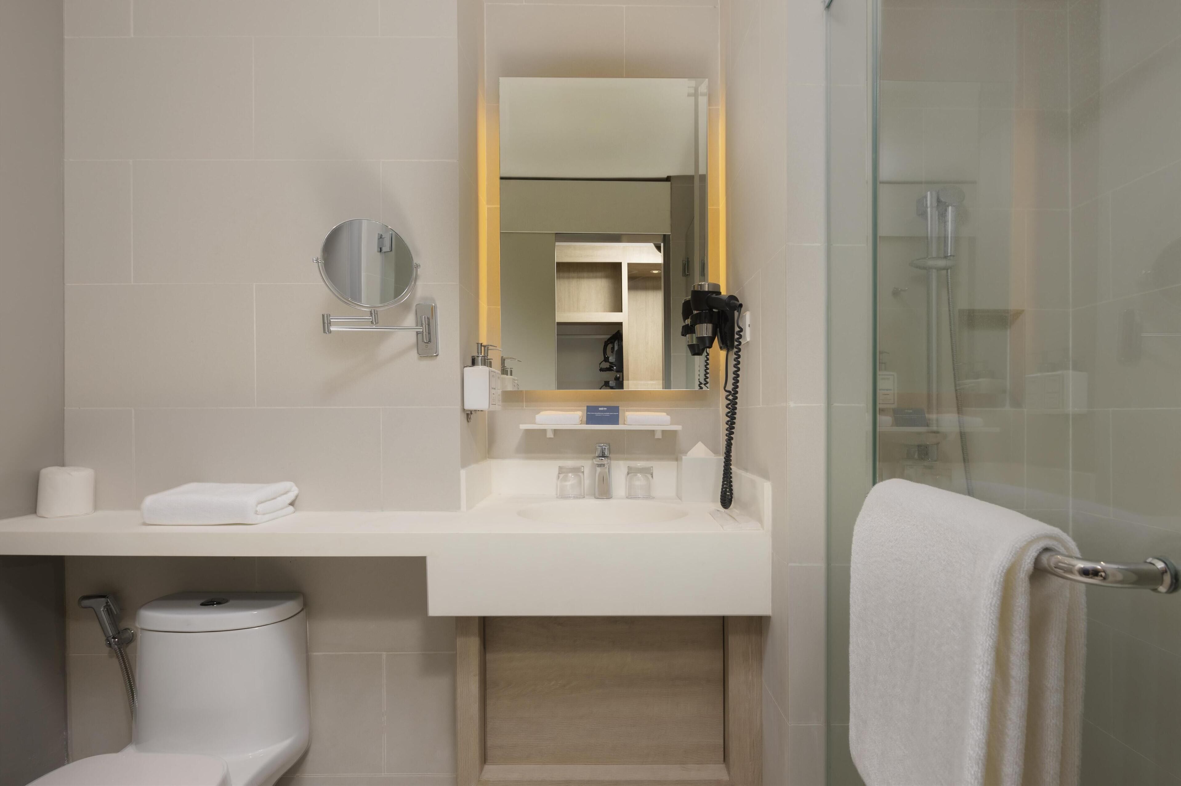 A modern bathroom with a toilet, sink, and shower.