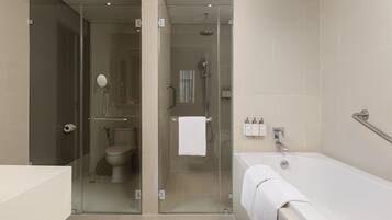 Une salle de bain moderne avec une douche à parois de verre, des toilettes et une baignoire.