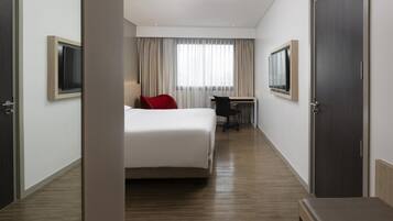 Une chambre d’hôtel équipée d’un lit, d’un bureau, d’une chaise et d’un téléviseur.