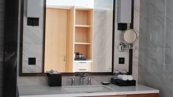 Un baño moderno con un espejo grande, un lavabo doble y un mueble de tocador de madera.