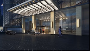 A modern hotel entrance with a glass facade, a covered entrance area, and a car parked outside. - Radisson Hangzhou Qianjiang (Hangzhou)