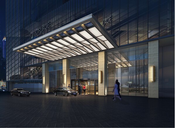Welcome to our hotel, featuring a sleek glass facade and a striking canopy above the entrance.