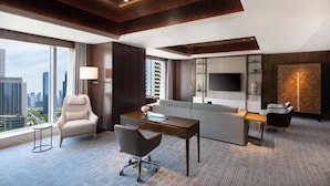 A modern hotel room with a large window, a desk, a sofa, and a TV. - Radisson Hangzhou Qianjiang (Hangzhou)