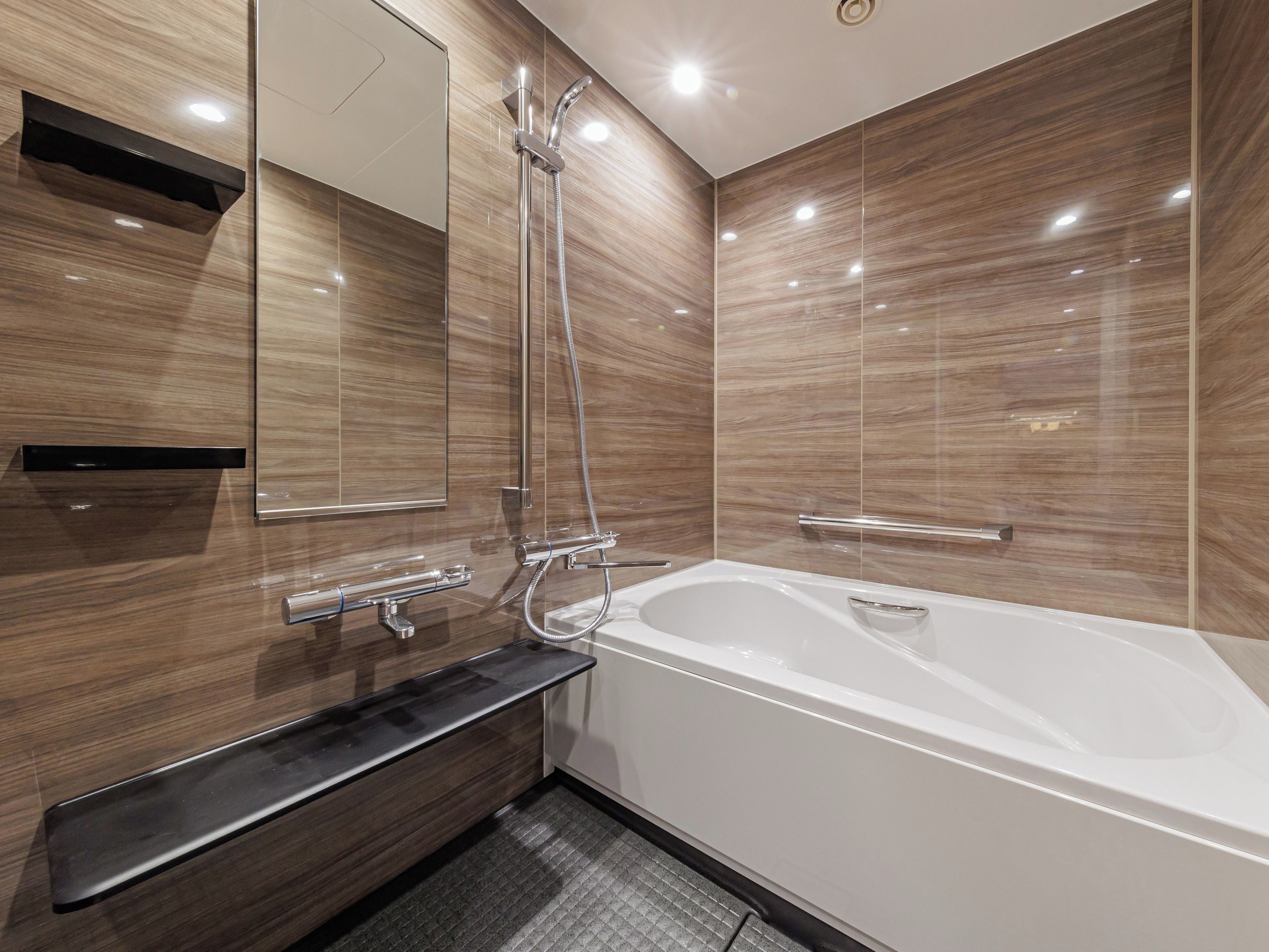 A modern bathroom with a freestanding bathtub, a vanity with a mirror, and a shower with a handheld showerhead.