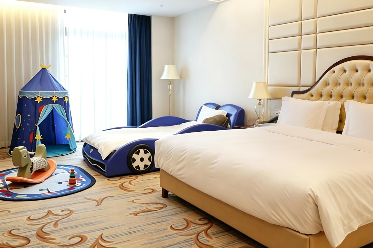 A hotel room with a large bed, a play tent, and a toy horse.