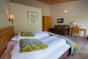 A bedroom with a large bed, a wooden wardrobe, a desk with a chair, and a television on the wall. - Gjaargardur Guesthouse Gjogv (Gjogv)