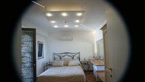 Ein Schlafzimmer mit einem Bett, Nachttischen, einer Klimaanlage und einer Deckenleuchte.