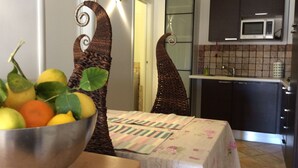 Eine Küche mit Mikrowelle, Schränken und einem Tisch mit Blumenmuster-Tischdecke.