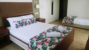 Ein Hotelzimmer mit einem großen Bett, einem Nachttisch und einer kleinen Couch.