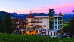 Un hotel con varias edificaciones, que incluye un restaurante y un bar, con montañas al fondo.