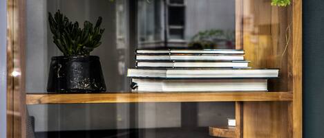 Ein Bücherregal aus Holz mit Büchern und Topfpflanzen.