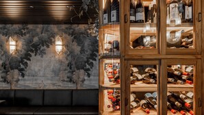 A wine cellar with wooden shelves and a bench.